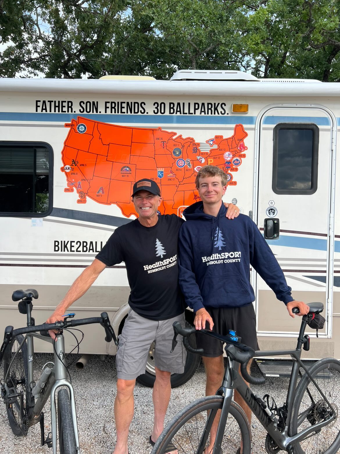 Father and son cyclists in HealthSPORT gear on their 30-ballpark ride